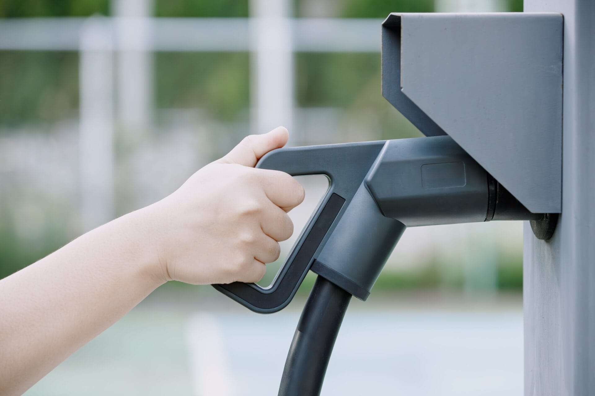 closeup-hand-holding-electric-car-charger-head