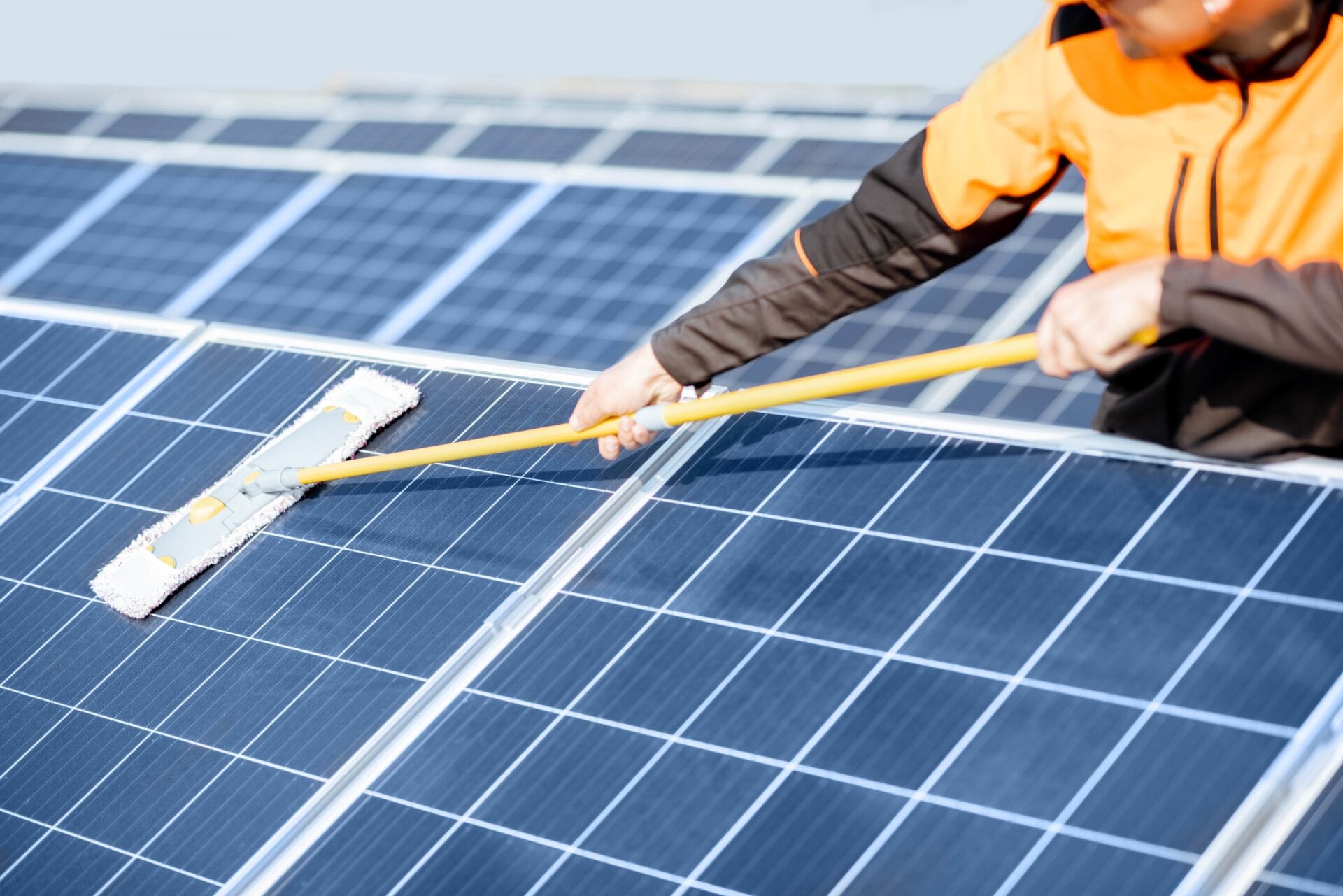 workman-cleaning-solar-panels